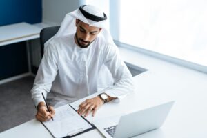 Handsome man with dish dasha working in an office of Dubai